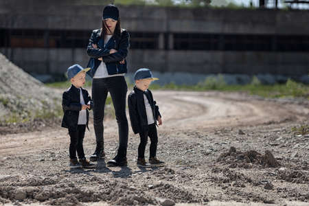Mom with twins in leather jackets and caps.Mother and sonsの写真素材