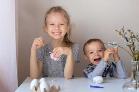 Brother and sister paint decorative Easter eggs with felt-tip pensの写真素材