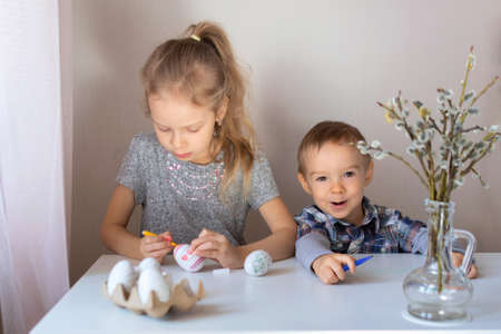 Brother and sister paint decorative Easter eggs with felt-tip pensの写真素材
