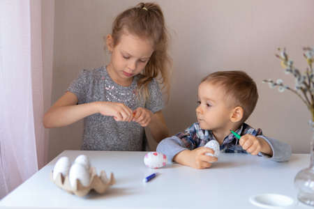Brother and sister paint decorative Easter eggs with felt-tip pensの写真素材