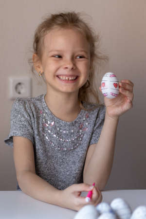 The little girl is preparing for Easter by painting decorative eggsの写真素材