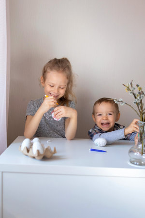 Brother and sister paint decorative Easter eggs with felt-tip pensの写真素材