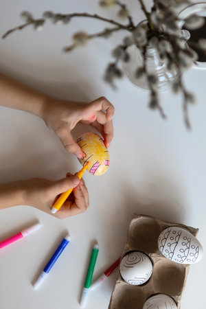 Childrens hands draw close-up on decorative Easter eggs.の写真素材