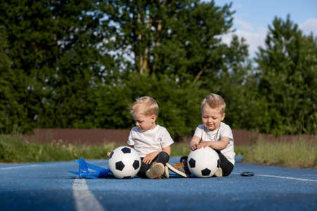 Twin brothers are playing on a walk.の写真素材