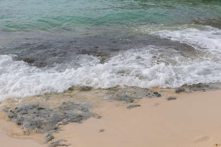 A sea wave runs onto the shore and breaks on rocks.A fragment of the seashoreの写真素材