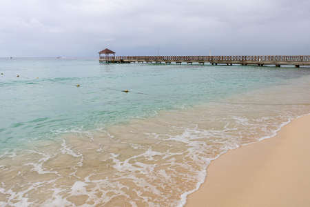 The blue sea water and the sky are separated by the horizon line, a pierの写真素材