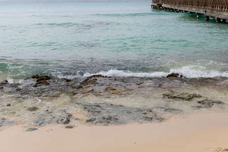 A sea wave runs onto the shore and breaks on rocks.A fragment of the seashoreの写真素材