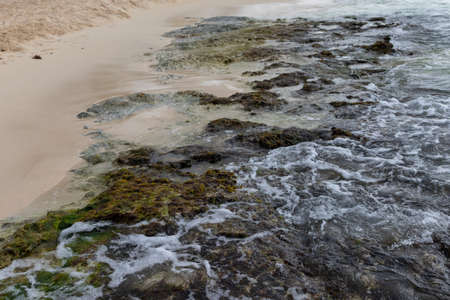 A sea wave runs onto the shore and breaks on rocks.A fragment of the seashoreの写真素材