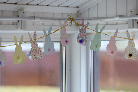 Cute Easter bunnies made of paper with yarn tails with pompoms.の写真素材