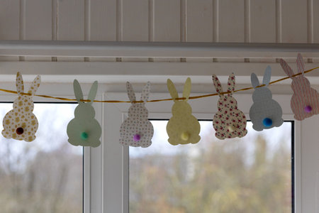 Cute Easter bunnies made of paper with yarn tails with pompoms.の写真素材