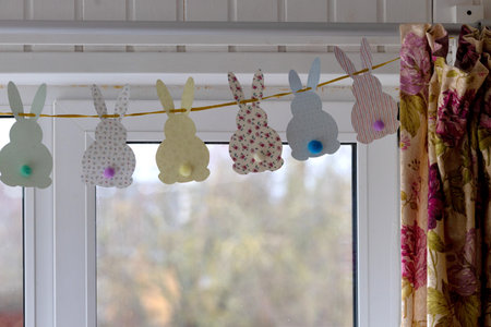 The window of the house is decorated with a garland for Easterの写真素材