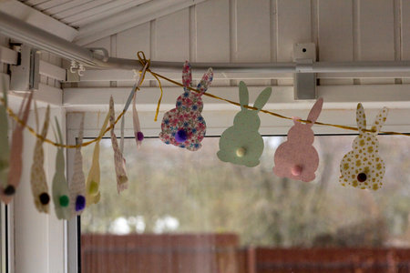 Cute Easter bunnies made of paper with yarn tails with pompoms.の写真素材
