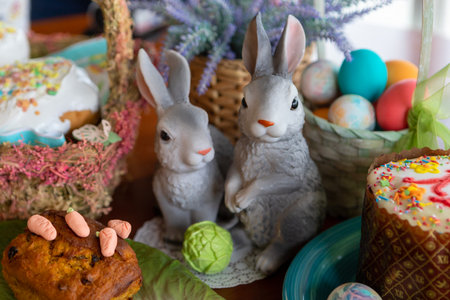Two decorative figurines of rabbits in close-up.Easter cakes, painted eggs