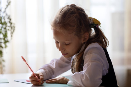 A schoolgirl is sitting at a table and studying.Education and distance learning