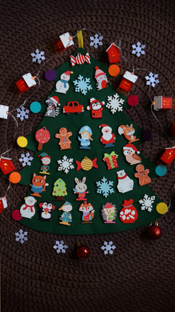 Advent calendar in the form of a felt Christmas tree with red Velcro pouches.の写真素材