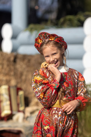 A girl in a national costume made of a fur cape and kokoshnikの写真素材