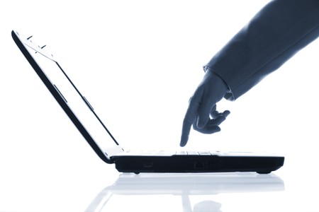 Close-up of  hand touching computer keys during workの写真素材