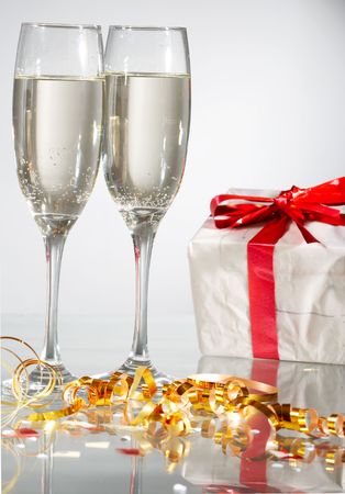 Glasses of champagne, gifts with red tapes and bowsの写真素材