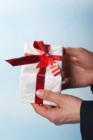 man holiday and offering a gift on his handの写真素材