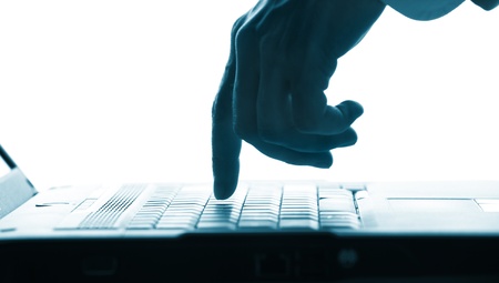 Close-up of  hand touching computer keys during workの写真素材