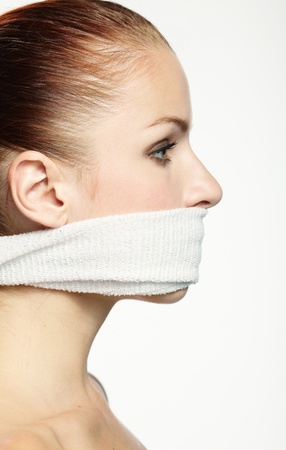 Cute young woman with white band on the mouthの写真素材