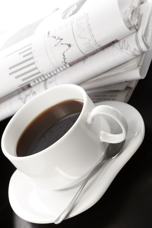 Cup of fragrant coffee on a morning paper business newsの写真素材