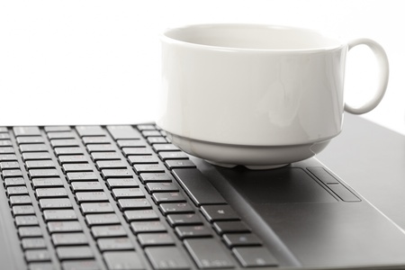 Cup of fragrant coffee on a laptopの写真素材