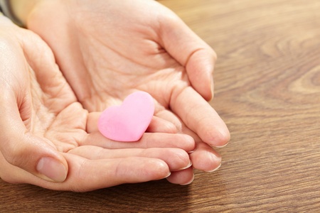 Woman holding pink heart in the hand の写真素材