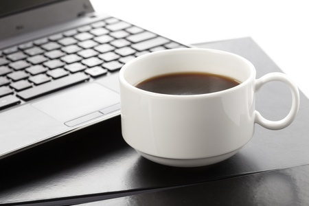 Cup of fragrant coffee on a laptopの写真素材