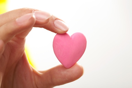 Woman holding pink heart in the hand の写真素材
