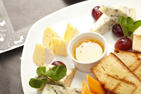 Cheese plate with grapes and honeyの写真素材
