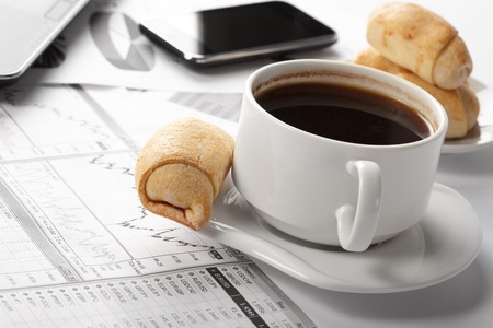Cup of fragrant coffee on a morning paper business newsの写真素材
