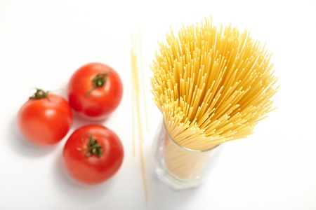 Raw spaghetti and  fresh tomatoesの写真素材