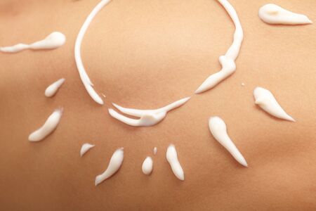 woman with sun-shaped sun cream の写真素材