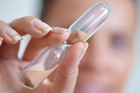 woman hand holding hourglass