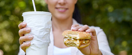 woman eating hamburger and cocktail