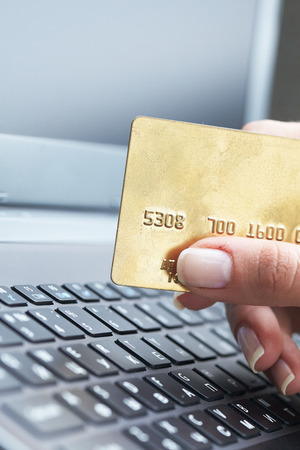 woman holding credit card on laptop for online shopping concepの写真素材
