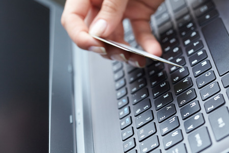 woman holding credit card on laptop for online shopping concep