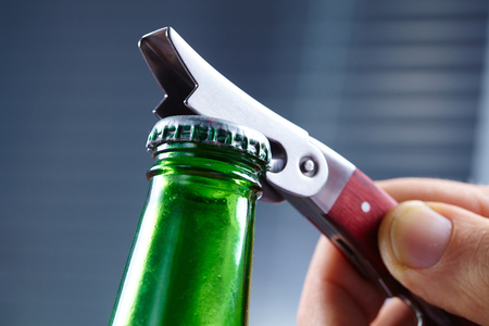 A hand opening a bottle of beerの写真素材