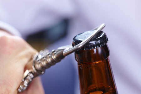 A hand opening a bottle of beerの写真素材