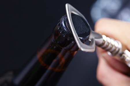 A hand opening a bottle of beerの写真素材