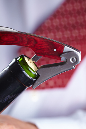 man opening a bottle of wineの写真素材