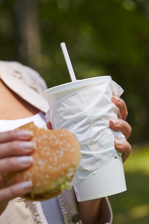 woman eating hamburger and cocktailの写真素材