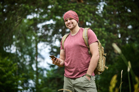 Young man on nature with mobile phoneの写真素材
