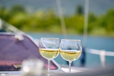 Pair of wineglasses against the yachtの写真素材