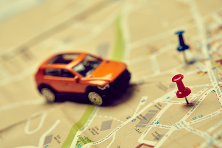 travel concept - small toy car on the mapの写真素材