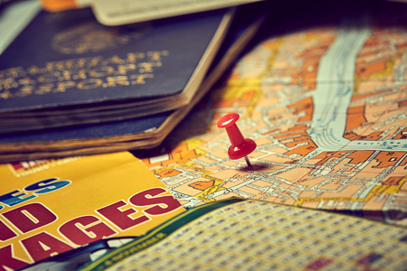 pins marking travel itinerary points on map and passportの写真素材