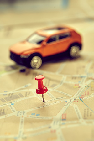 travel concept - small toy car on the mapの写真素材