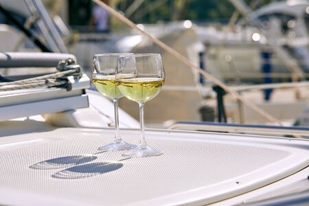 Pair of wineglasses against the yachtの写真素材