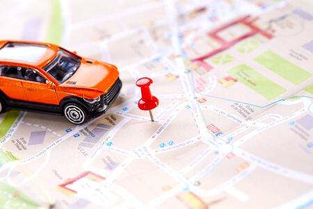 travel concept - small toy car on the mapの写真素材